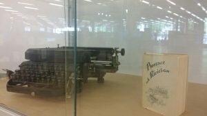antik skrivmaskin och bok i glasmonter